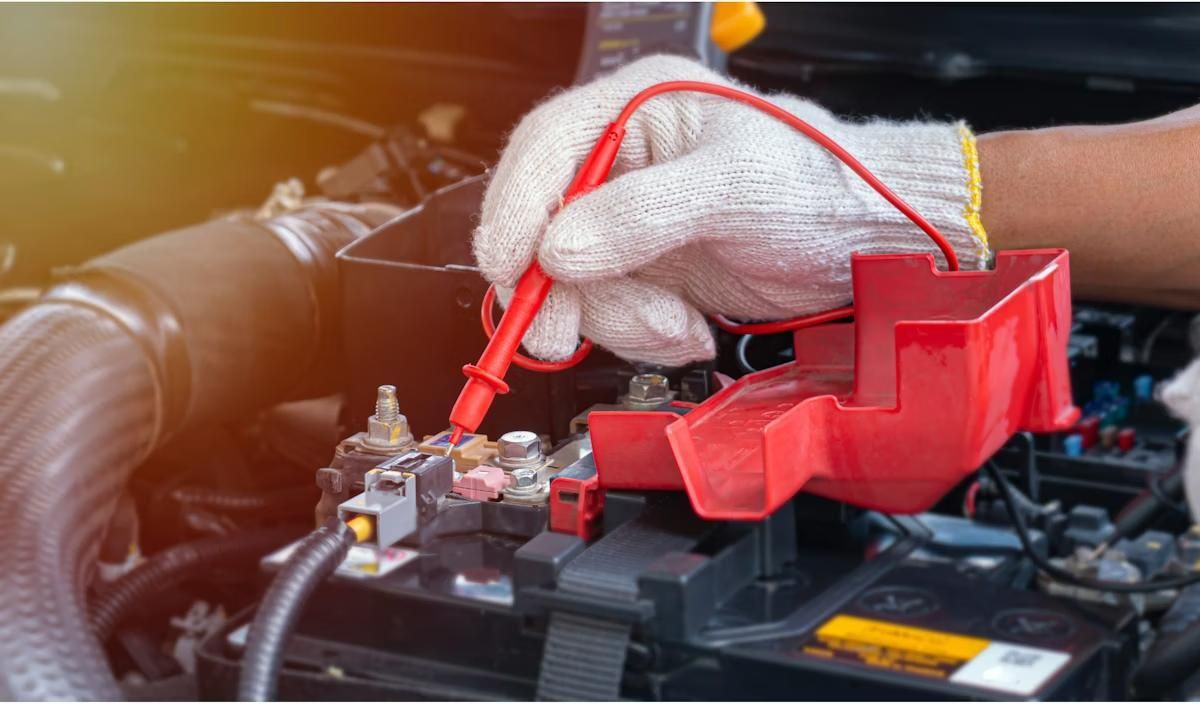 Gloved Hands Testing a Car Battery — Brian Turner Automotive in Stuart Park, NT
