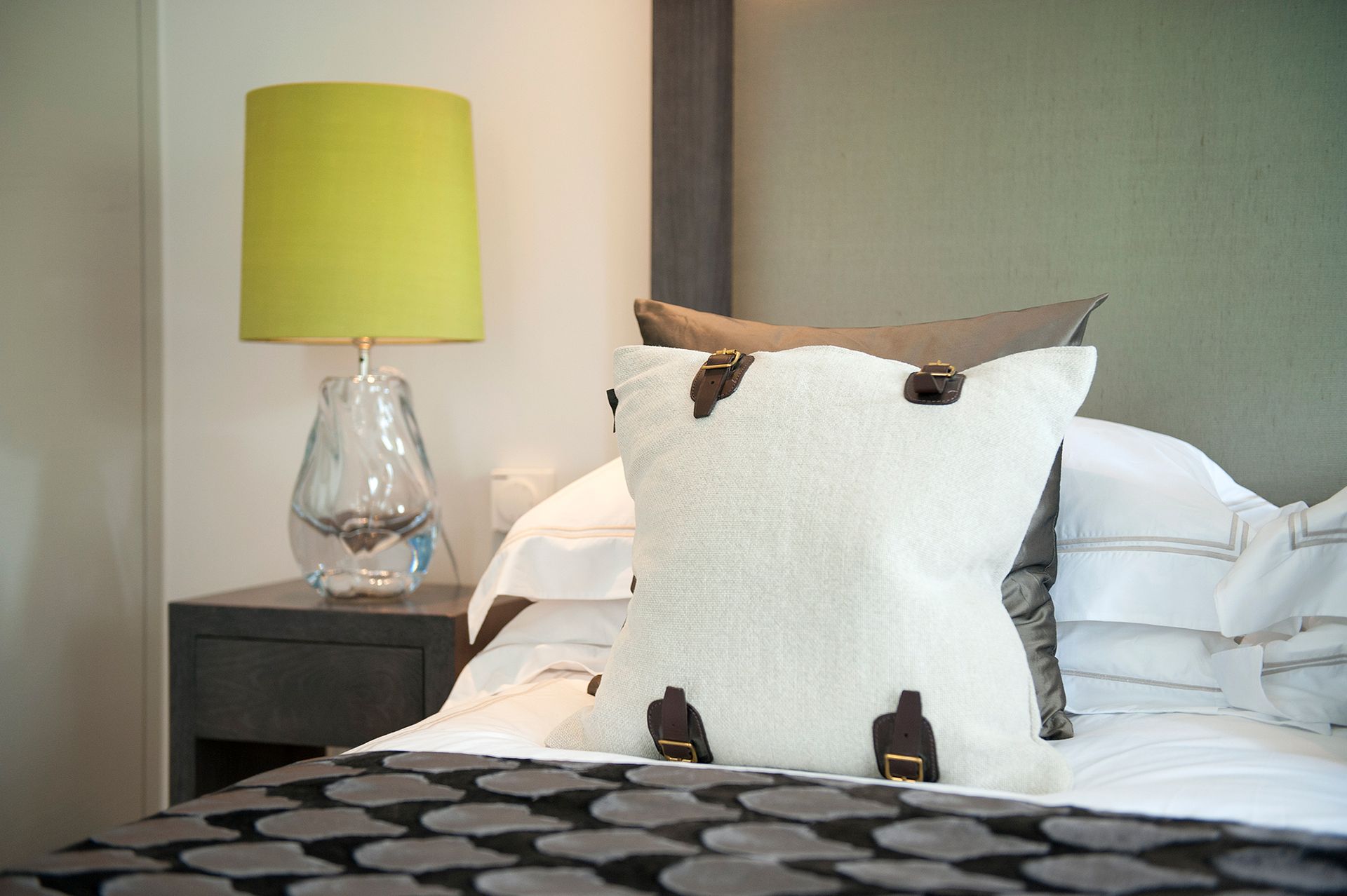 a bed with a lamp and a pillow on it
