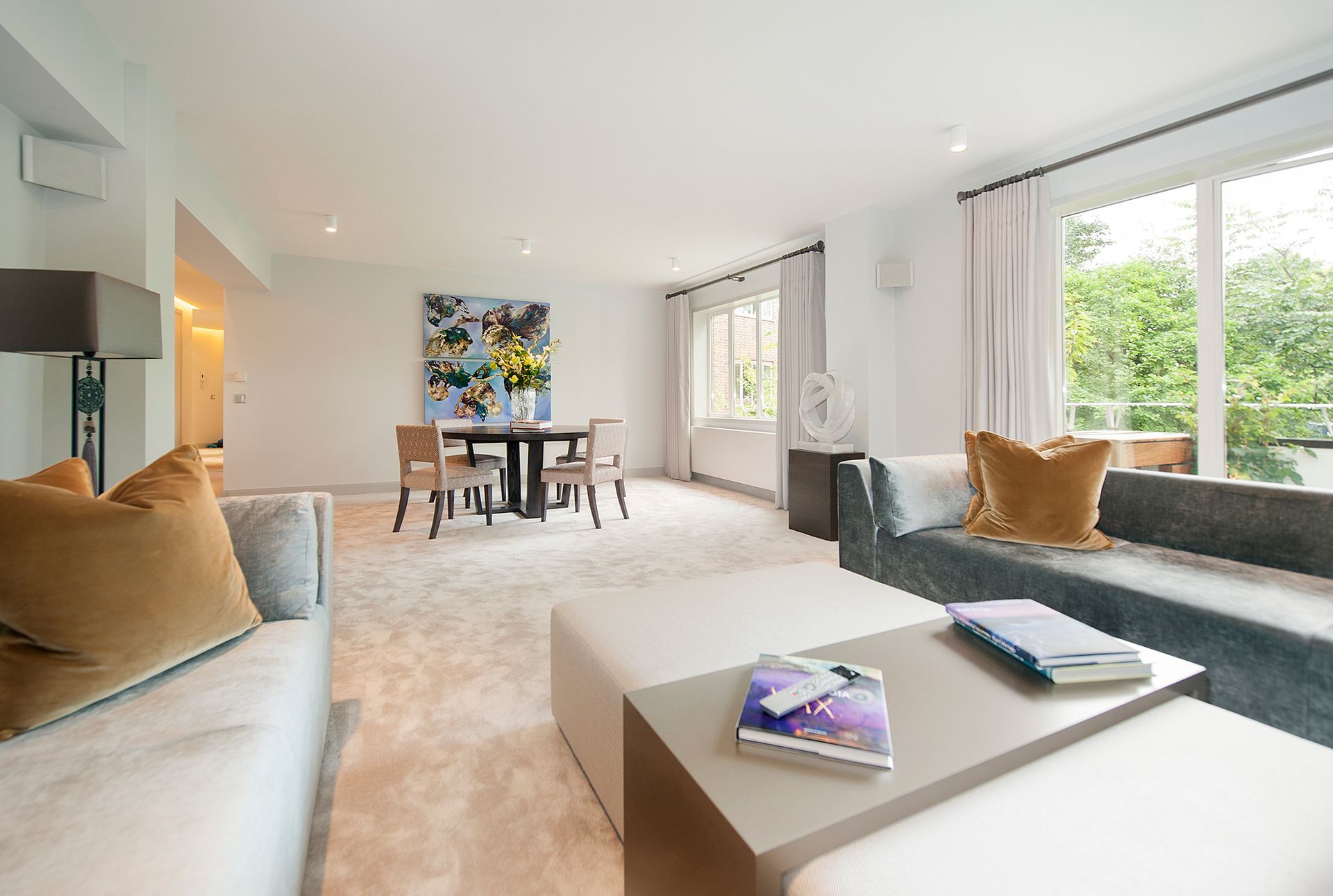 a living room with a couch , table , chairs and a painting on the wall 