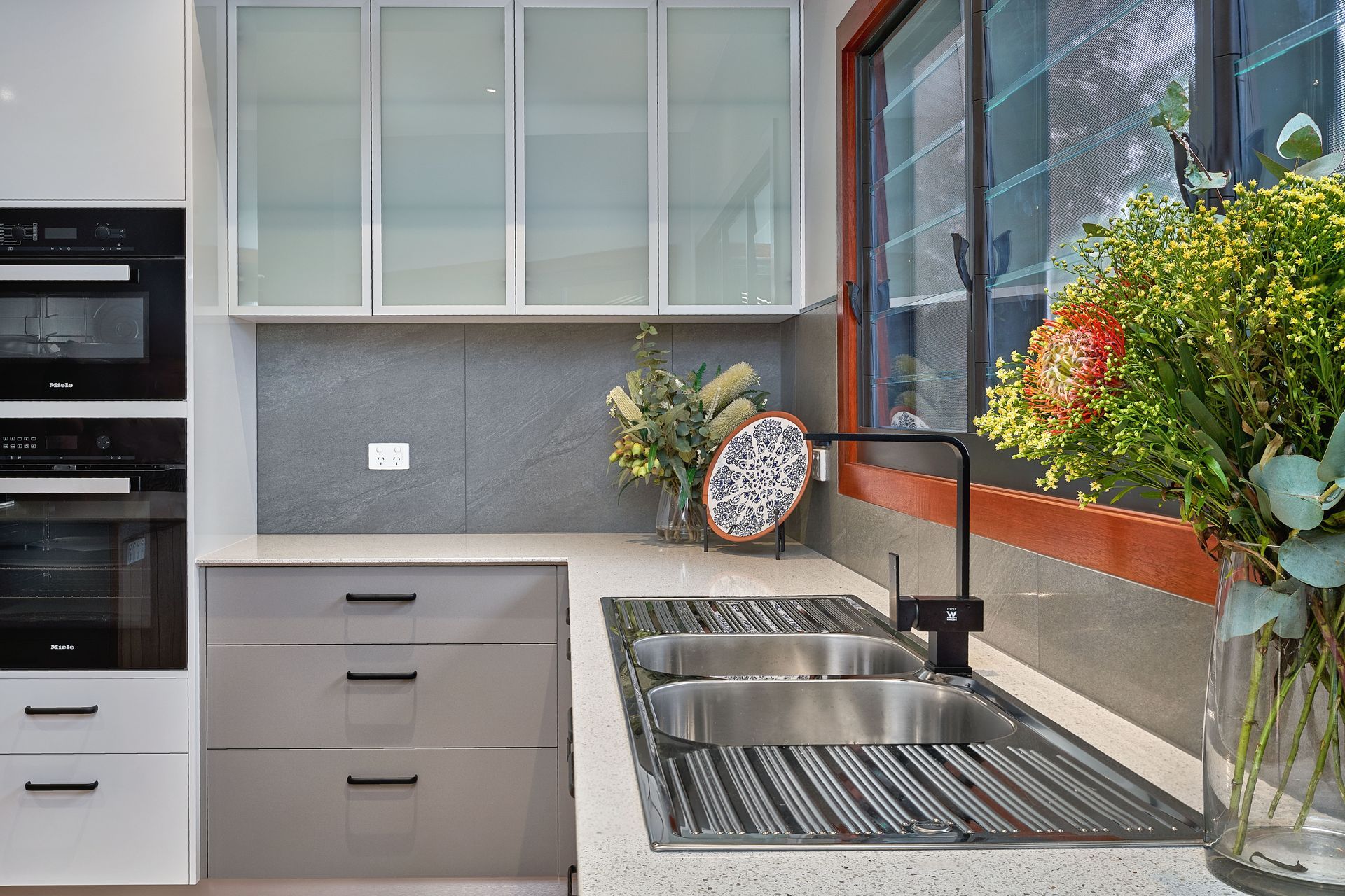 A Kitchen And Sink With Flowers — ROGA Build Solutions in Atherton, QLD