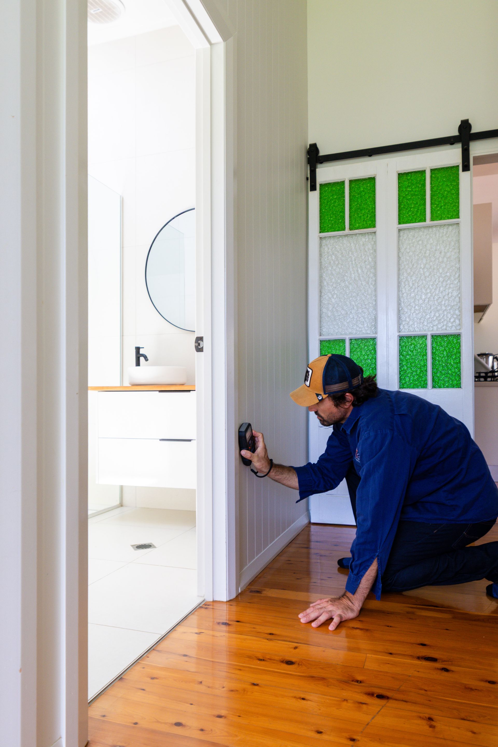 A Man Is Testing A Wall With A Monitor — ROGA Build Solutions in Atherton, QLD 