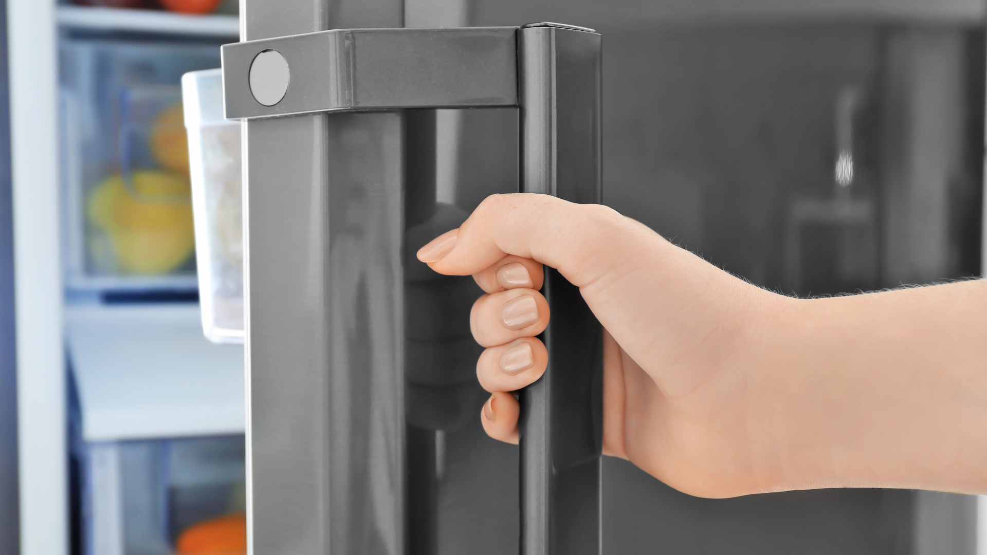 Close-up of a greasy range hood filter being removed for cleaning, illustrating a commonly overlooked kitchen crevice.