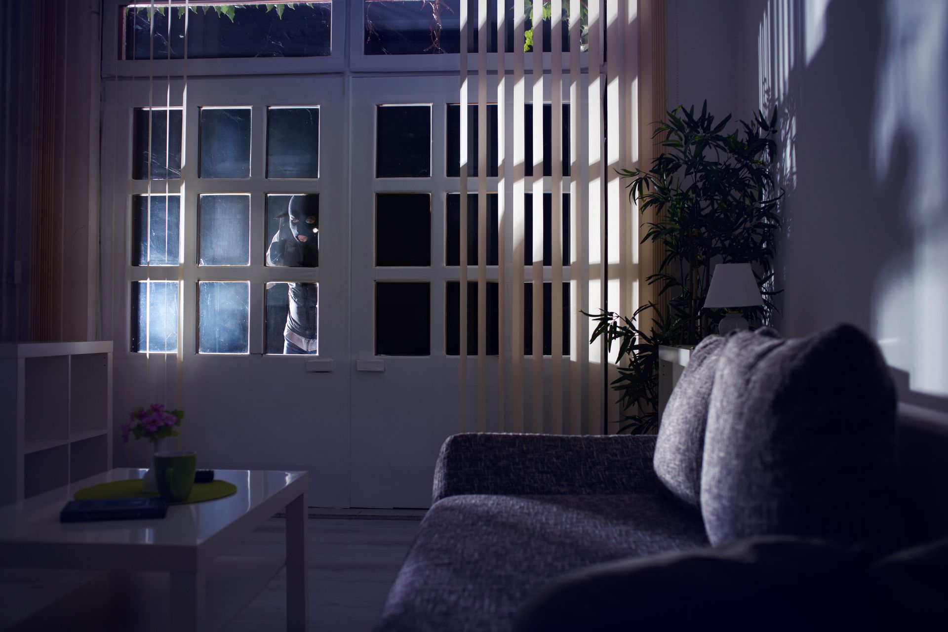 A burglar looking inside a dark house at night. A burglar looking inside a dark house at night.