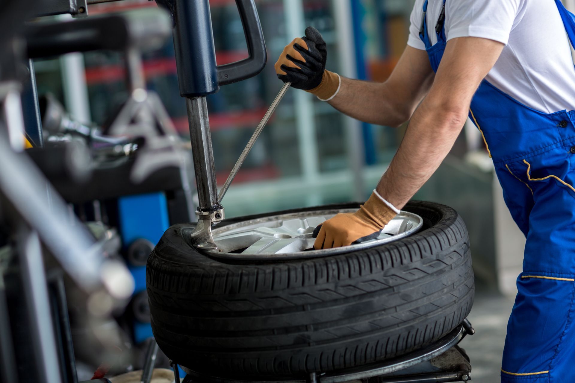 Un homme change un pneu sur une machine dans un garage.