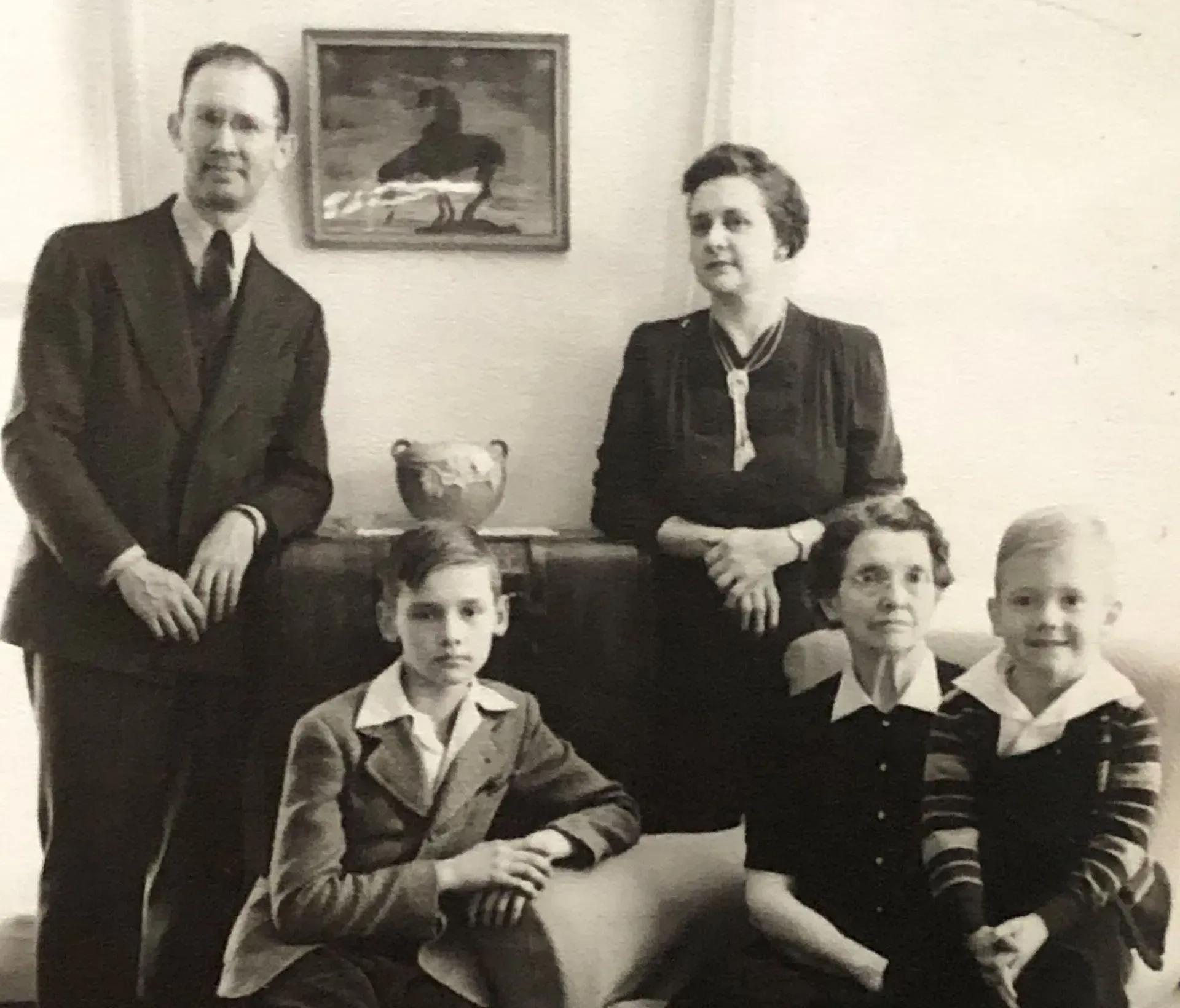 Formal family portrait with five people posed indoors in black-and-white.