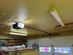 Ceiling-mounted fluorescent lights and a projector in a classroom or workshop room