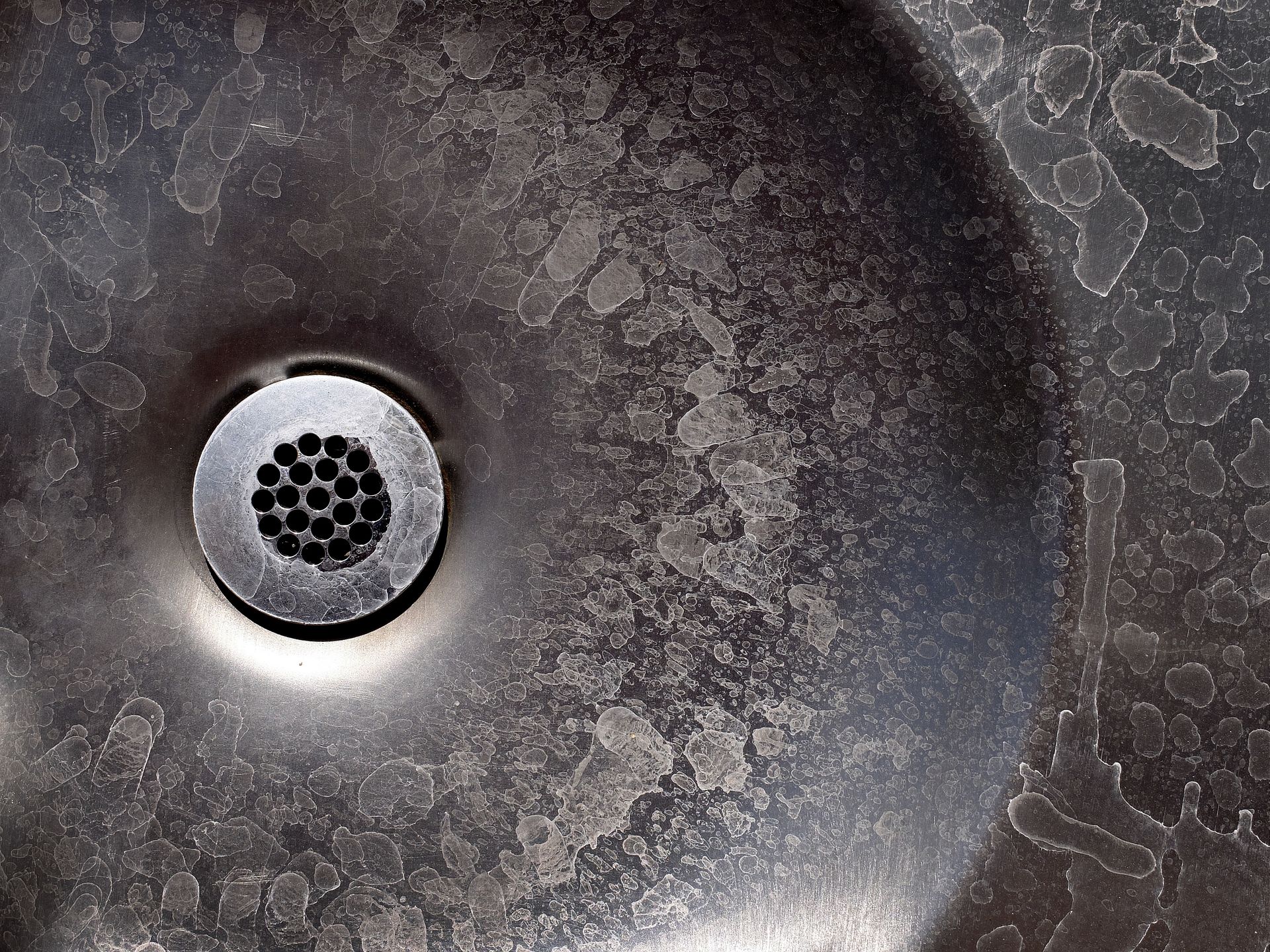 Old Metal Drain with Water Stains on Steel Sink.