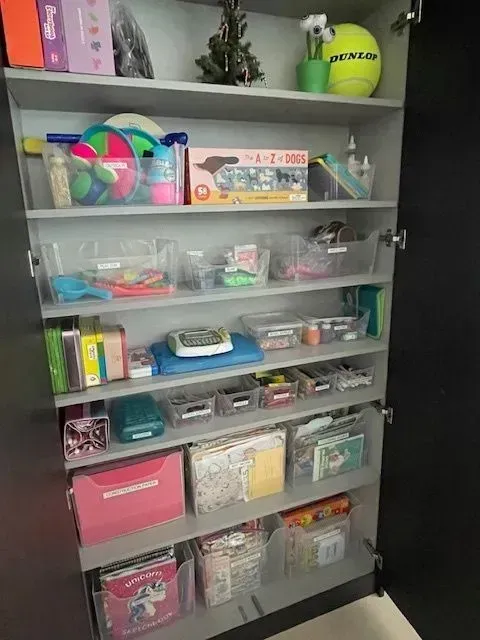 A room with a changing table and shelves full of toys