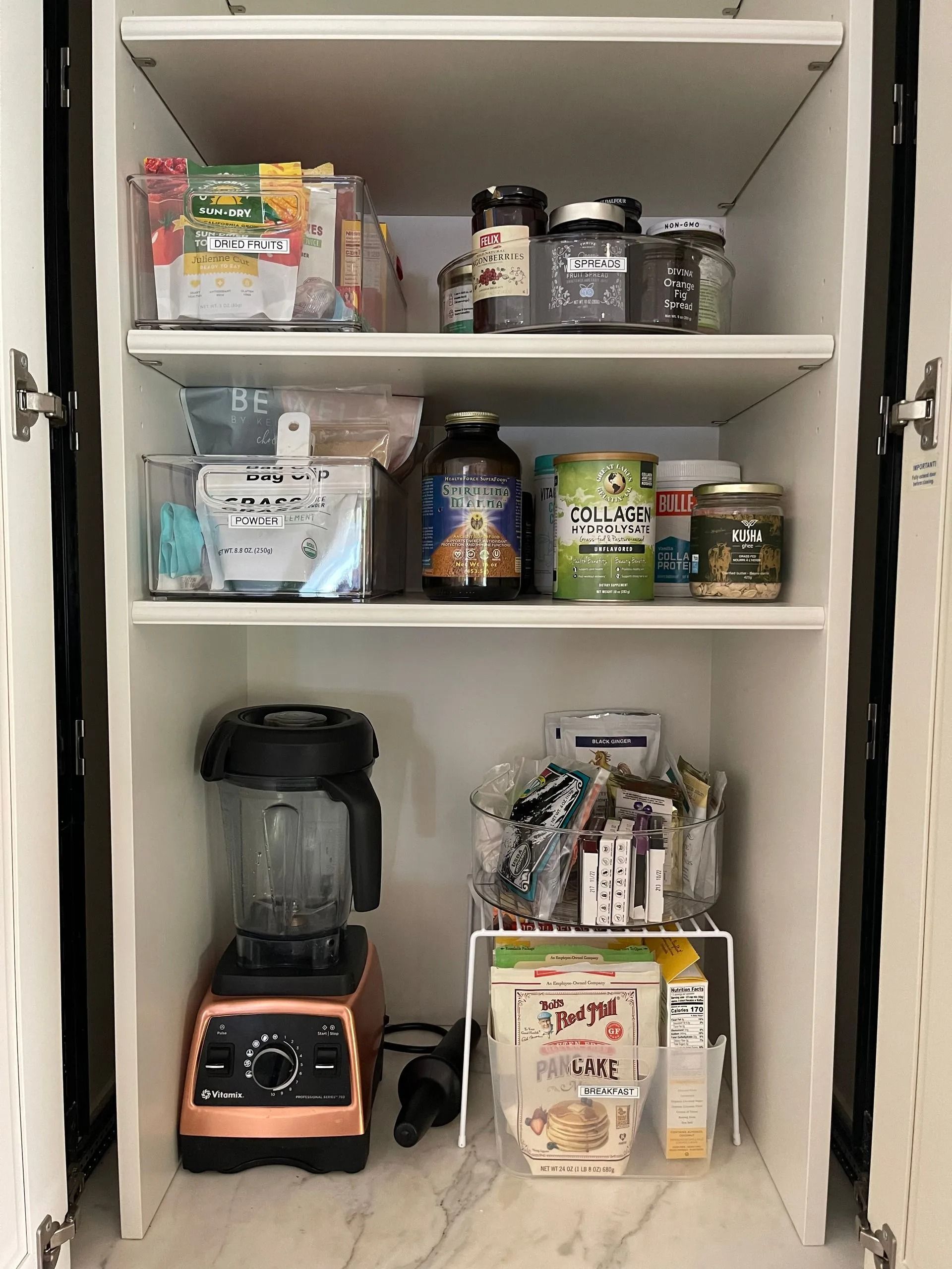 A pantry filled with lots of food and a blender.