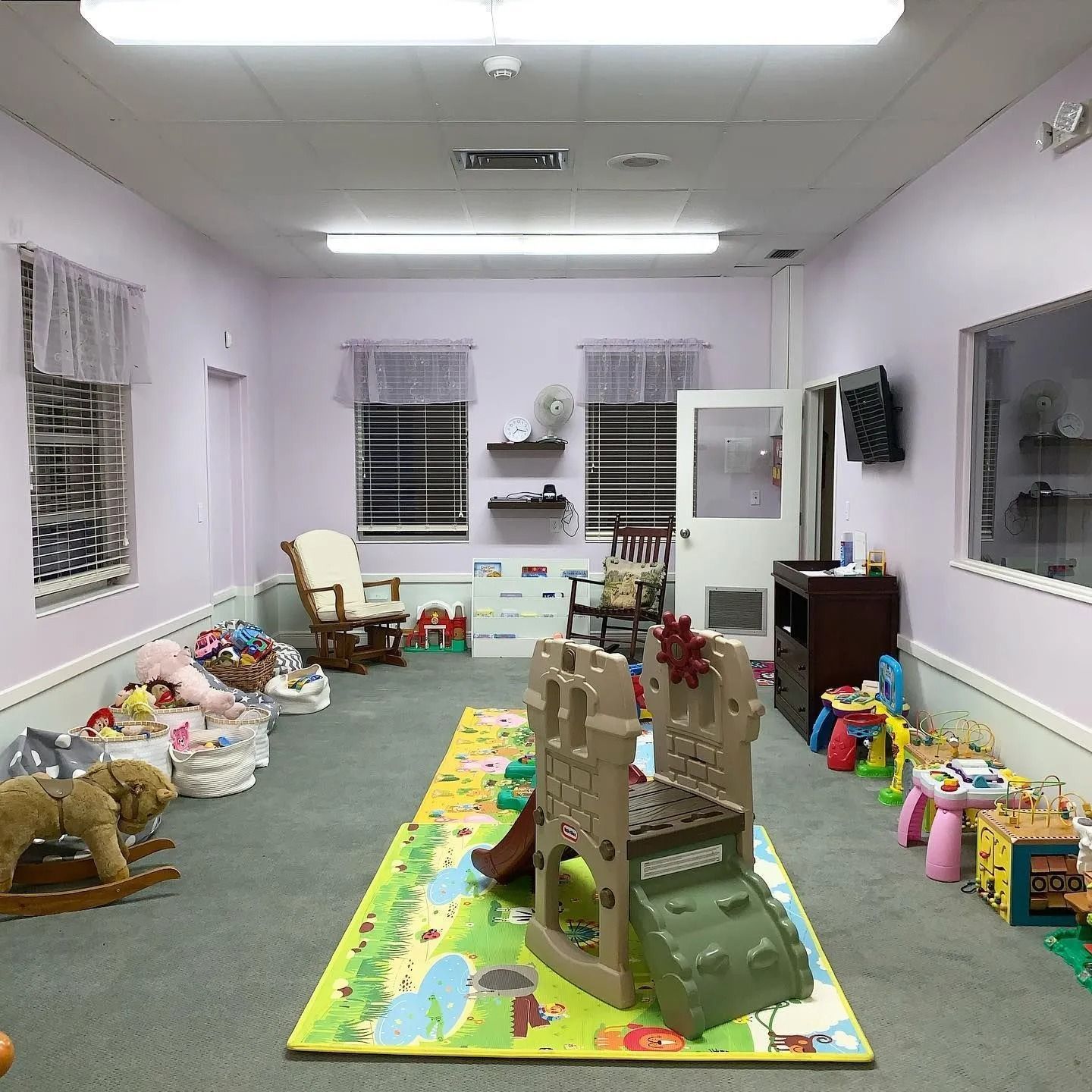 A room filled with lots of toys and a rocking horse.