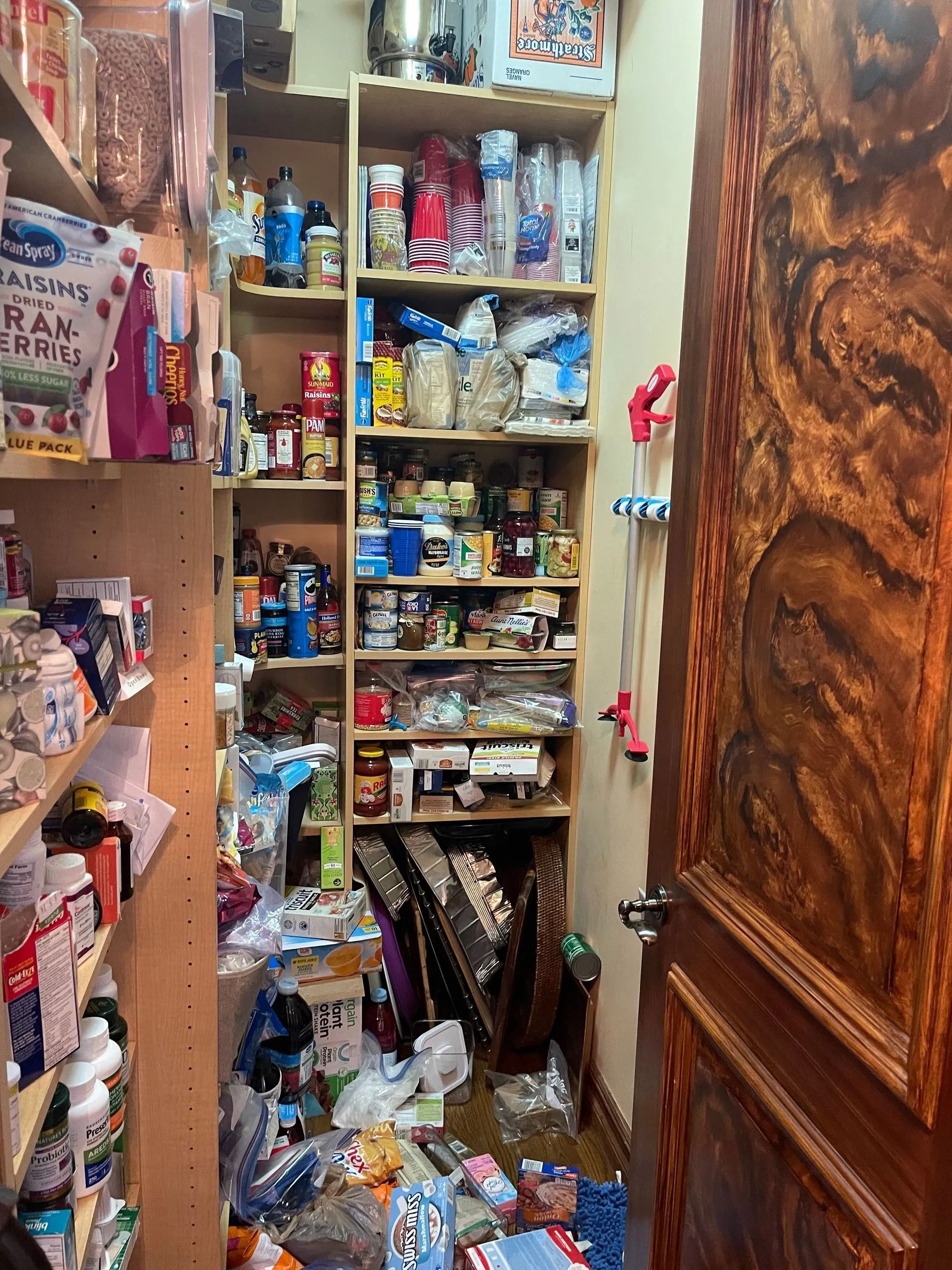 A very messy pantry with a lot of food on the shelves.