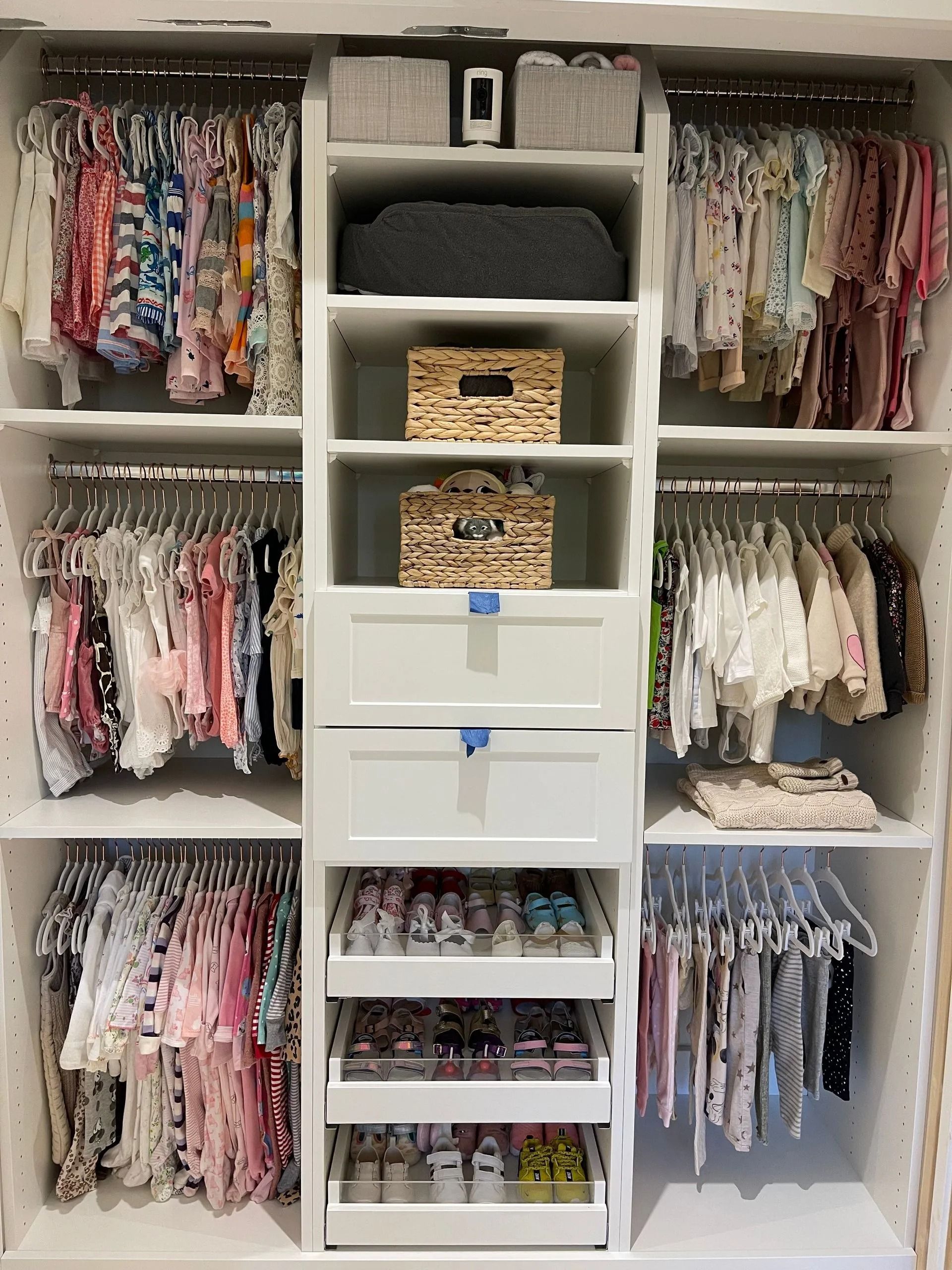 A closet filled with lots of baby clothes and shoes.