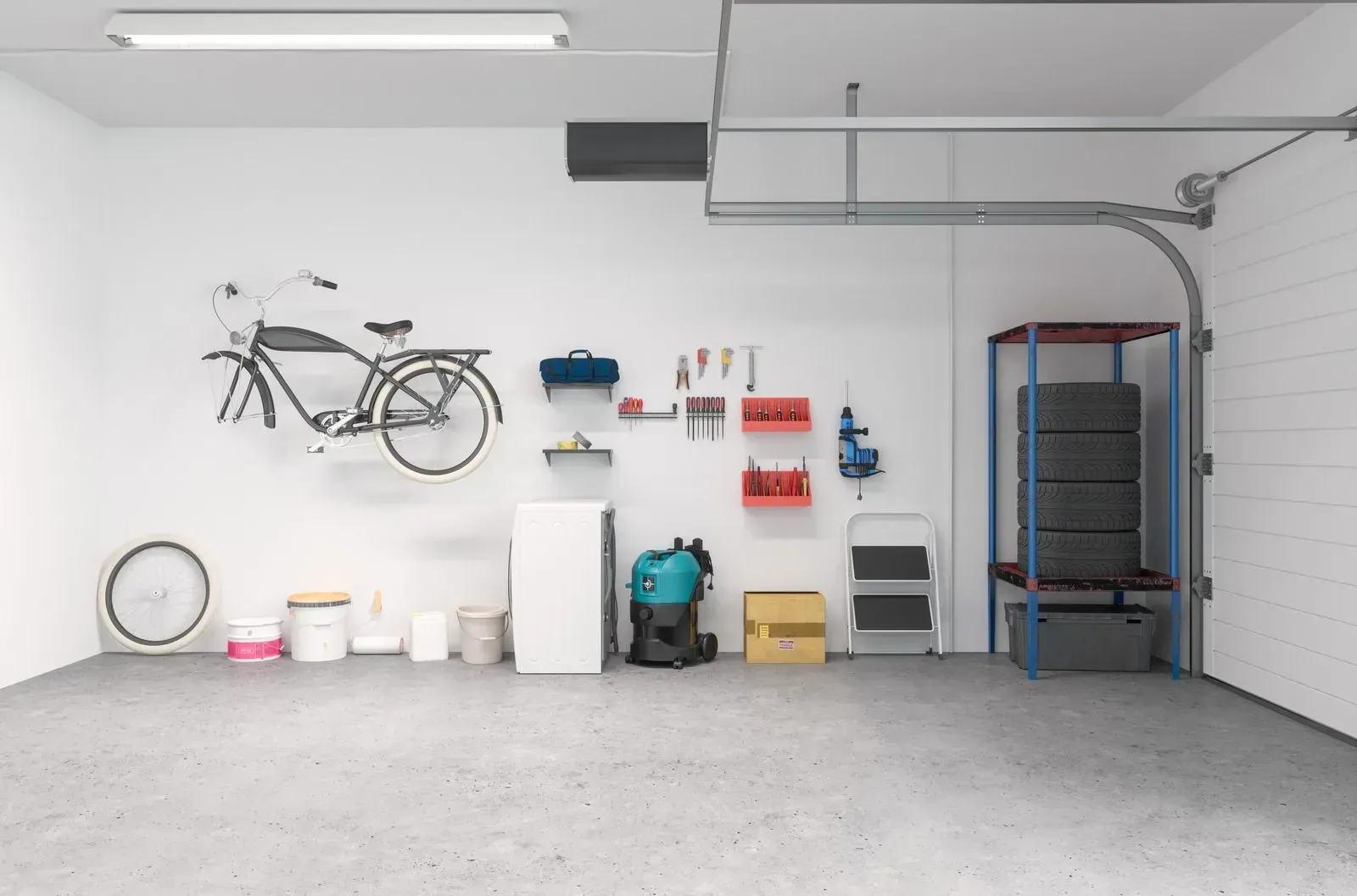 A well-organized garage with tools, a bike, and tires. White walls and a gray concrete floor.