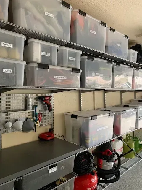 A garage filled with lots of storage bins and tools.