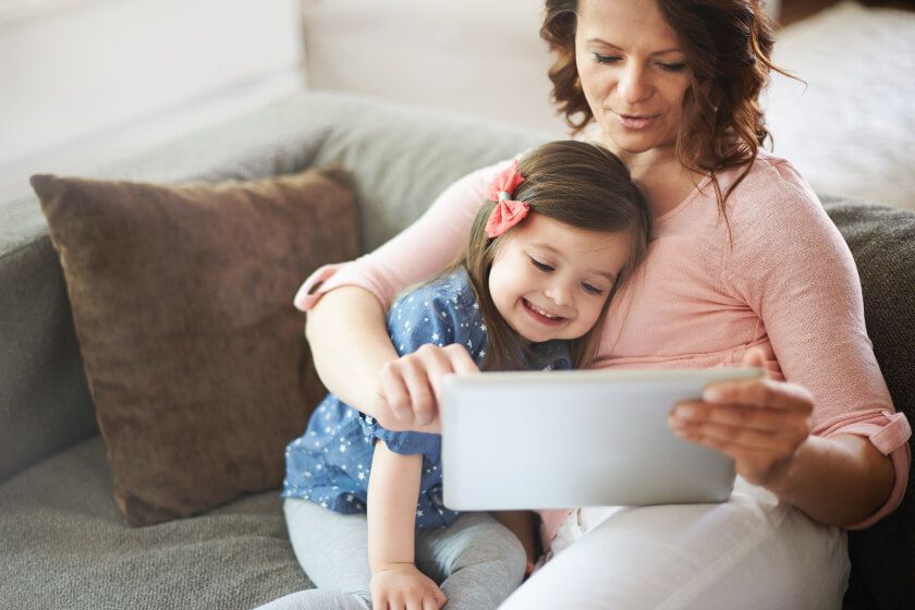 A woman and child looking at a video