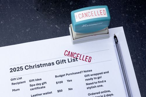 A cancelled stamp is on top of a christmas gift list.