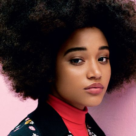 A woman with an afro and a red turtleneck