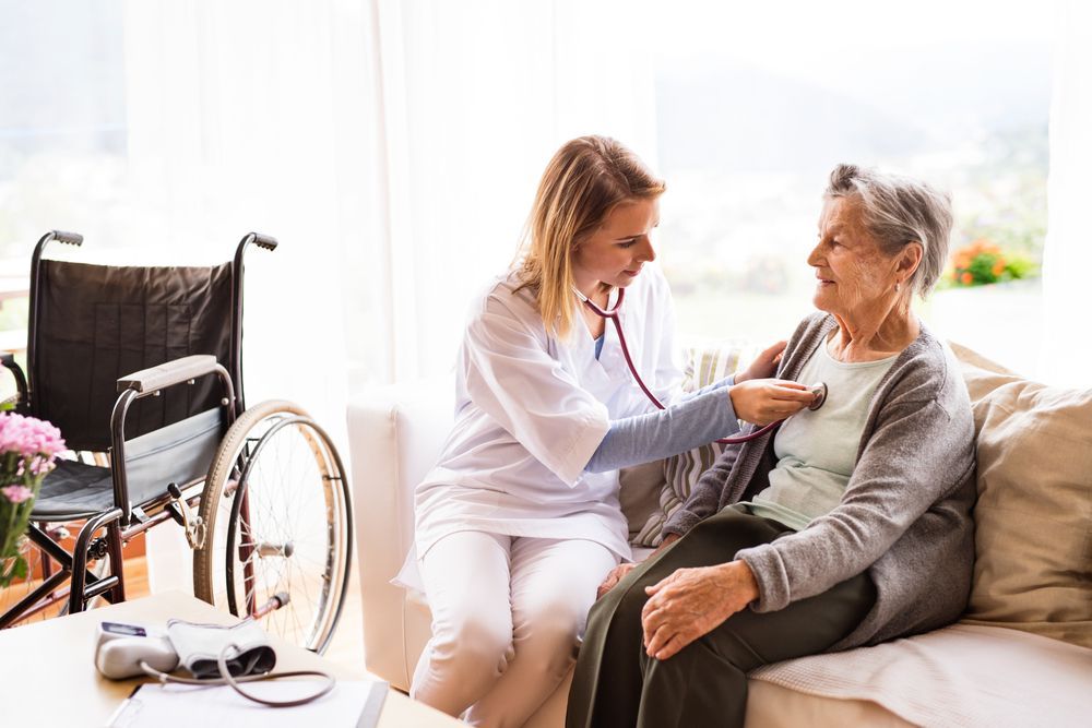 A Young Healthcare Worker Examines an Elderly Woman's Chest With a Stethoscope —Elder Care at Home in Highland Park, QLD