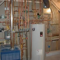 Copper pipes and water heater in a utility room.