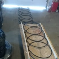 Black belts arranged in a line on a wooden surface, inside a building.
