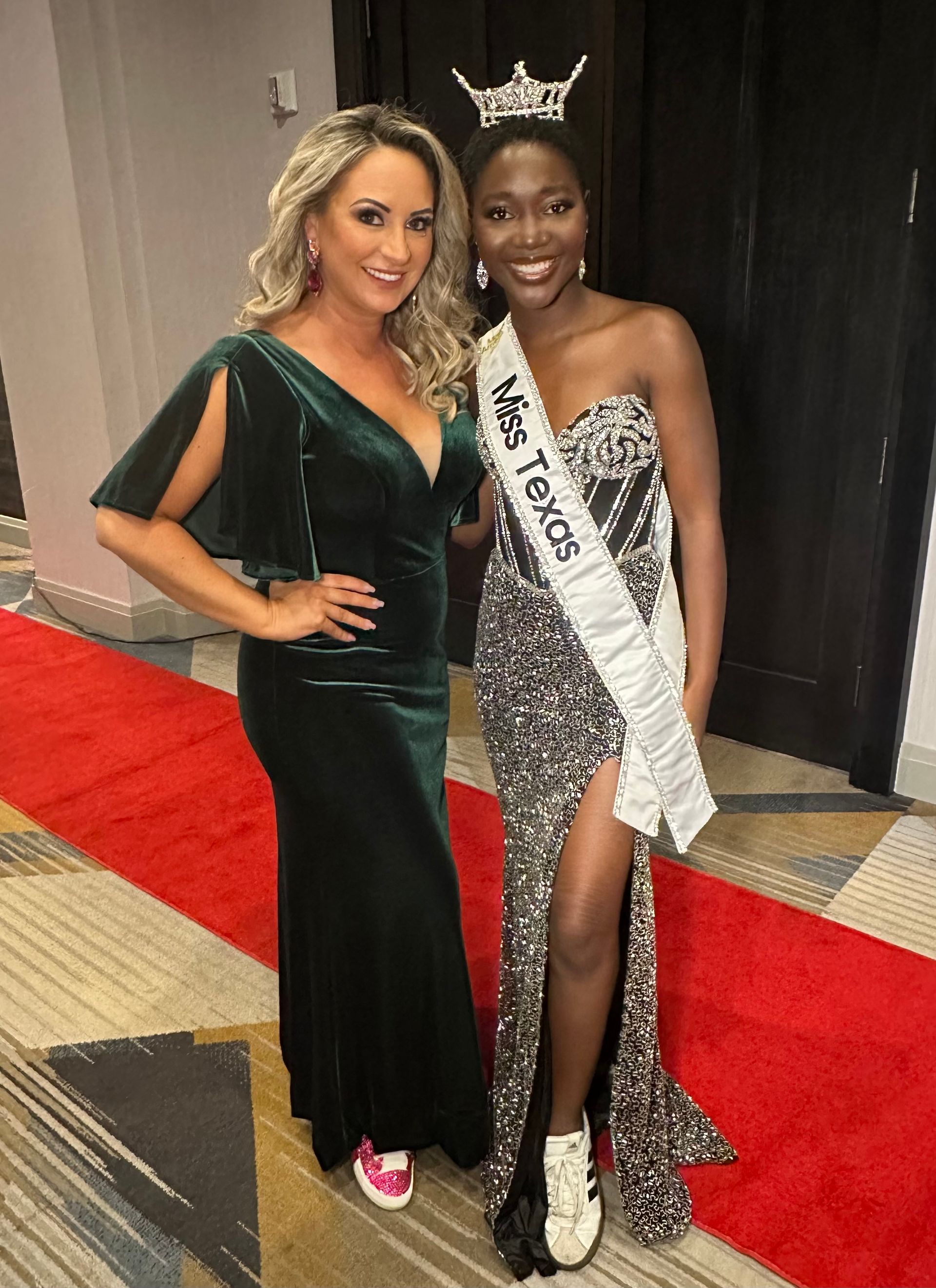 Woman in green dress poses with woman wearing crown and sash that says