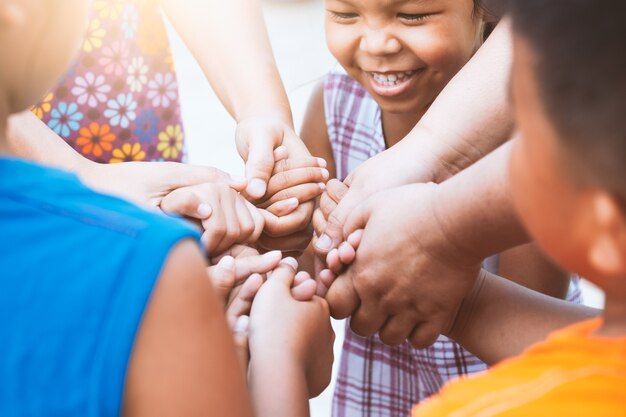 Children holding hands in a circle, one smiling brightly.