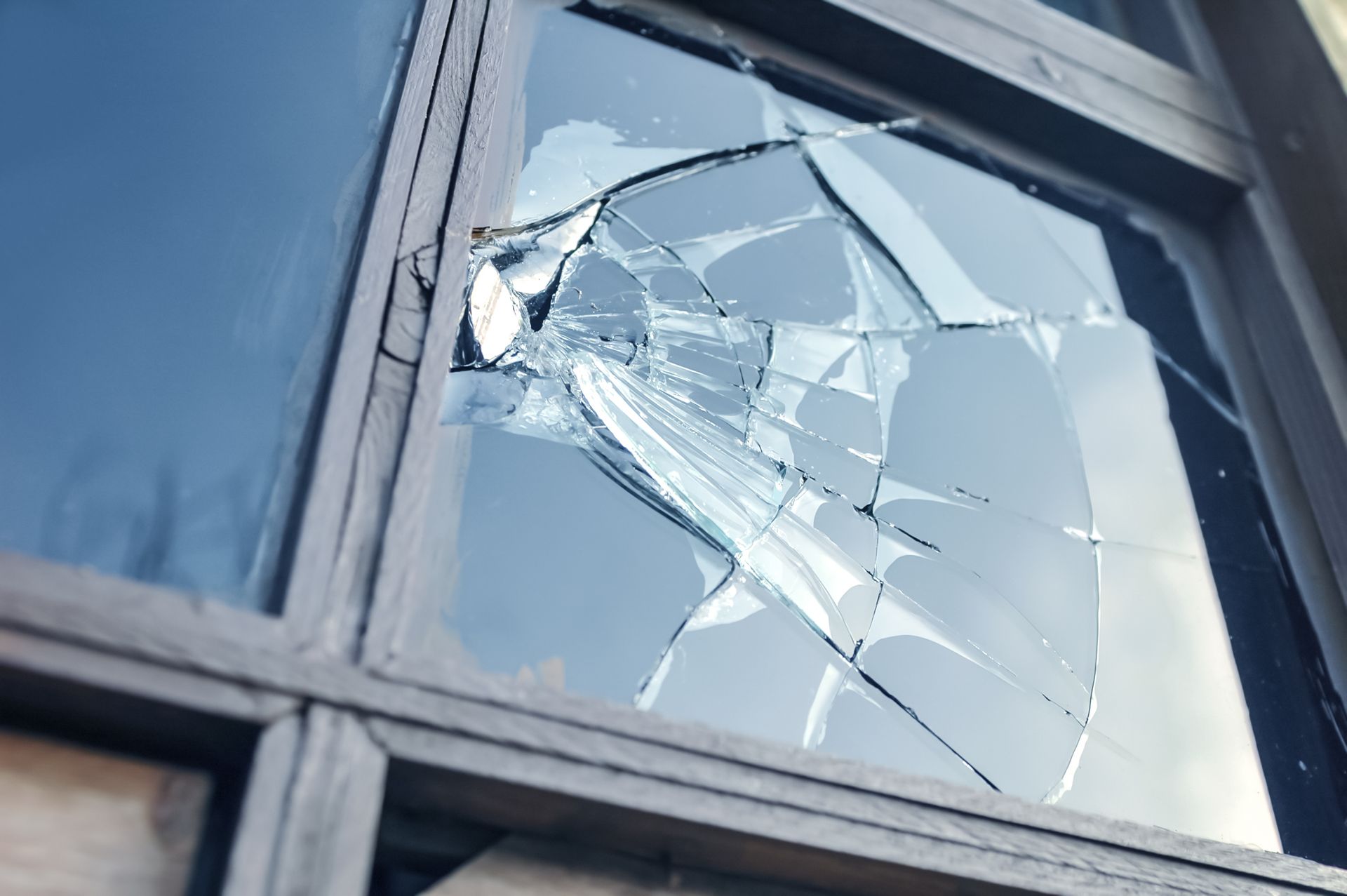 A close up of a broken glass window on a building.