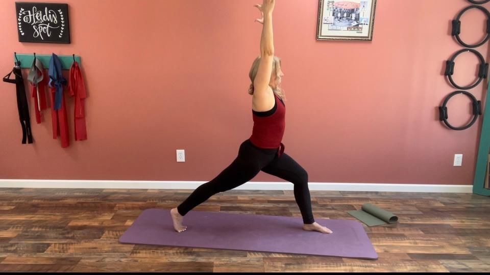 a woman is doing yoga on a purple mat in a room .