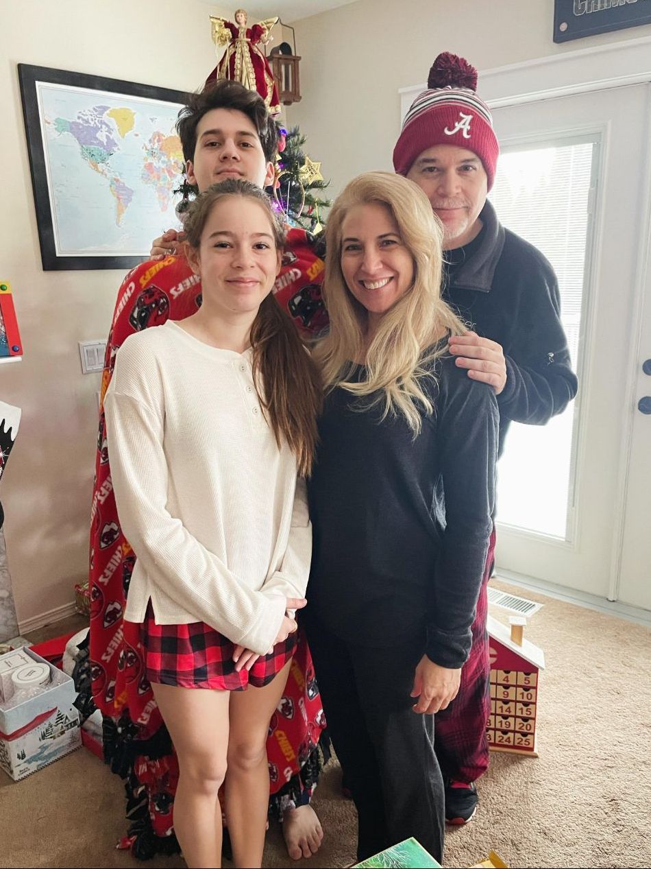 a family is posing for a picture in front of a christmas tree .