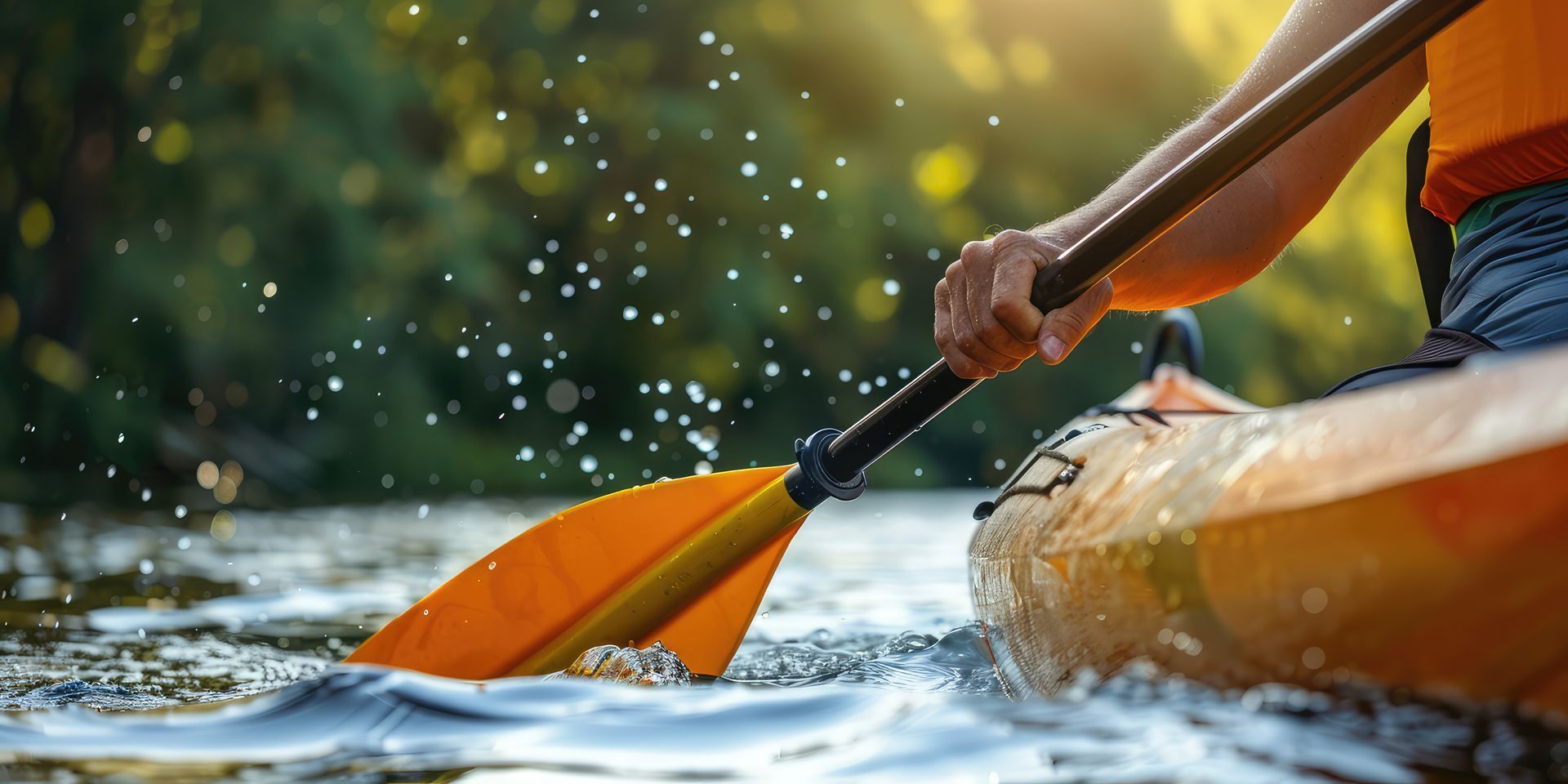 Kayaker paddling an orange kayak through splashing water on a river Kayaker paddling an orange kayak through splashing water on a river