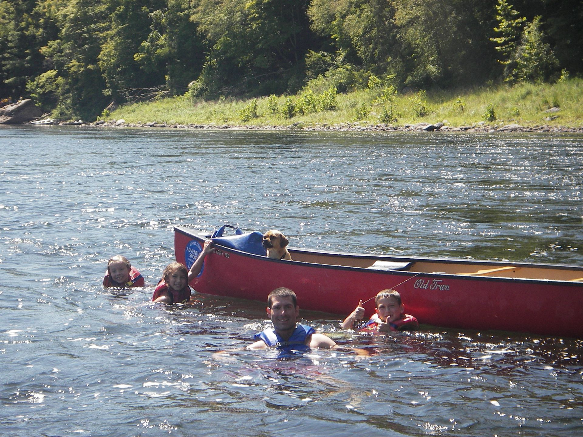 A group of people are in a red canoe on a lake