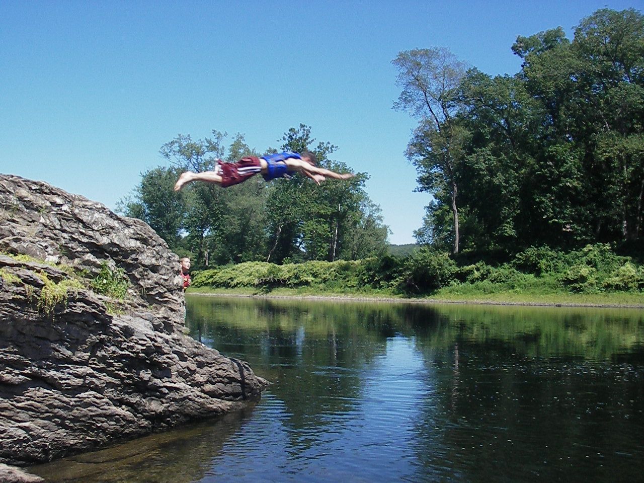 A person is jumping into the Delaware River