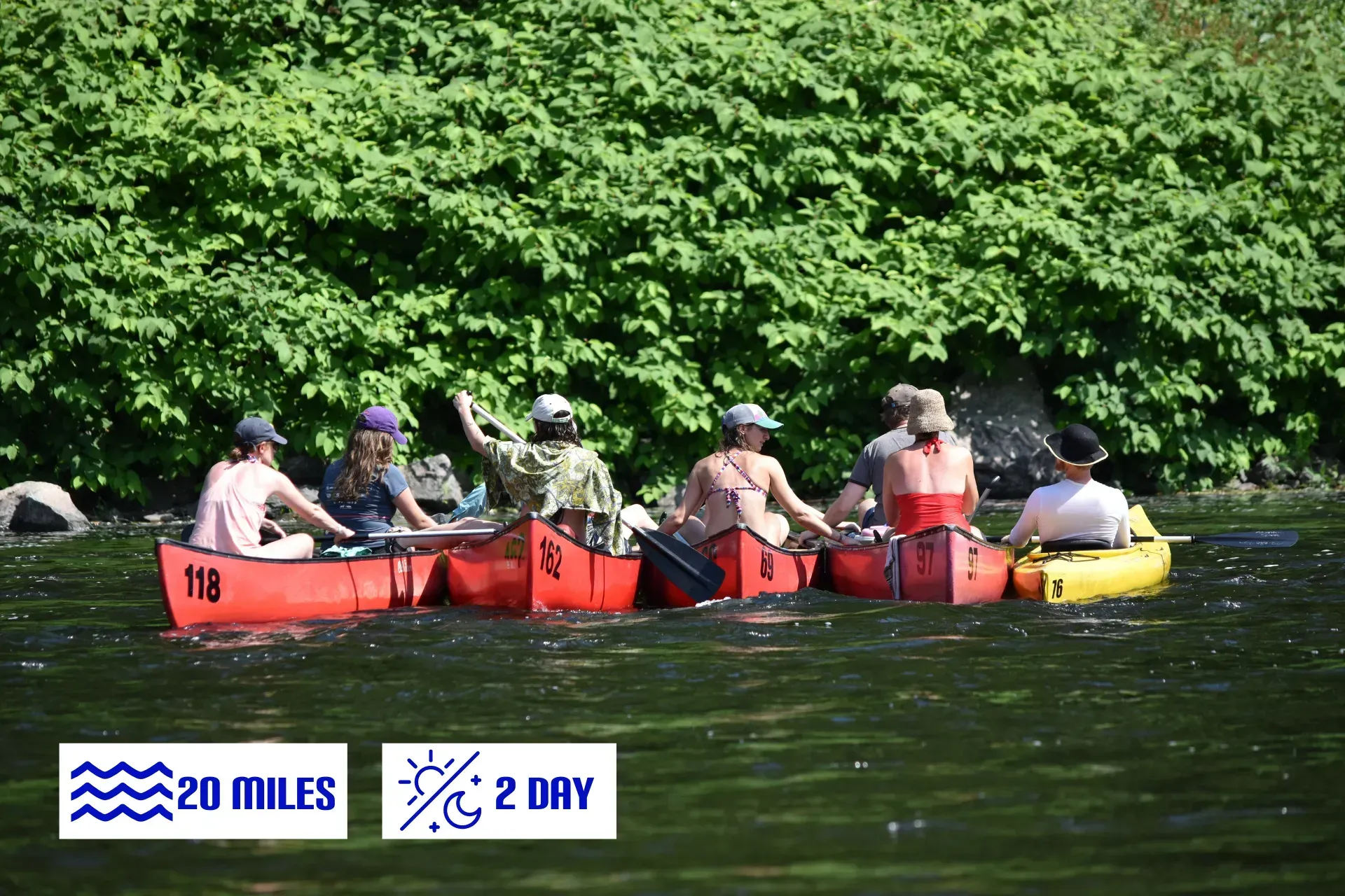 A group of people are in red canoes on a river
