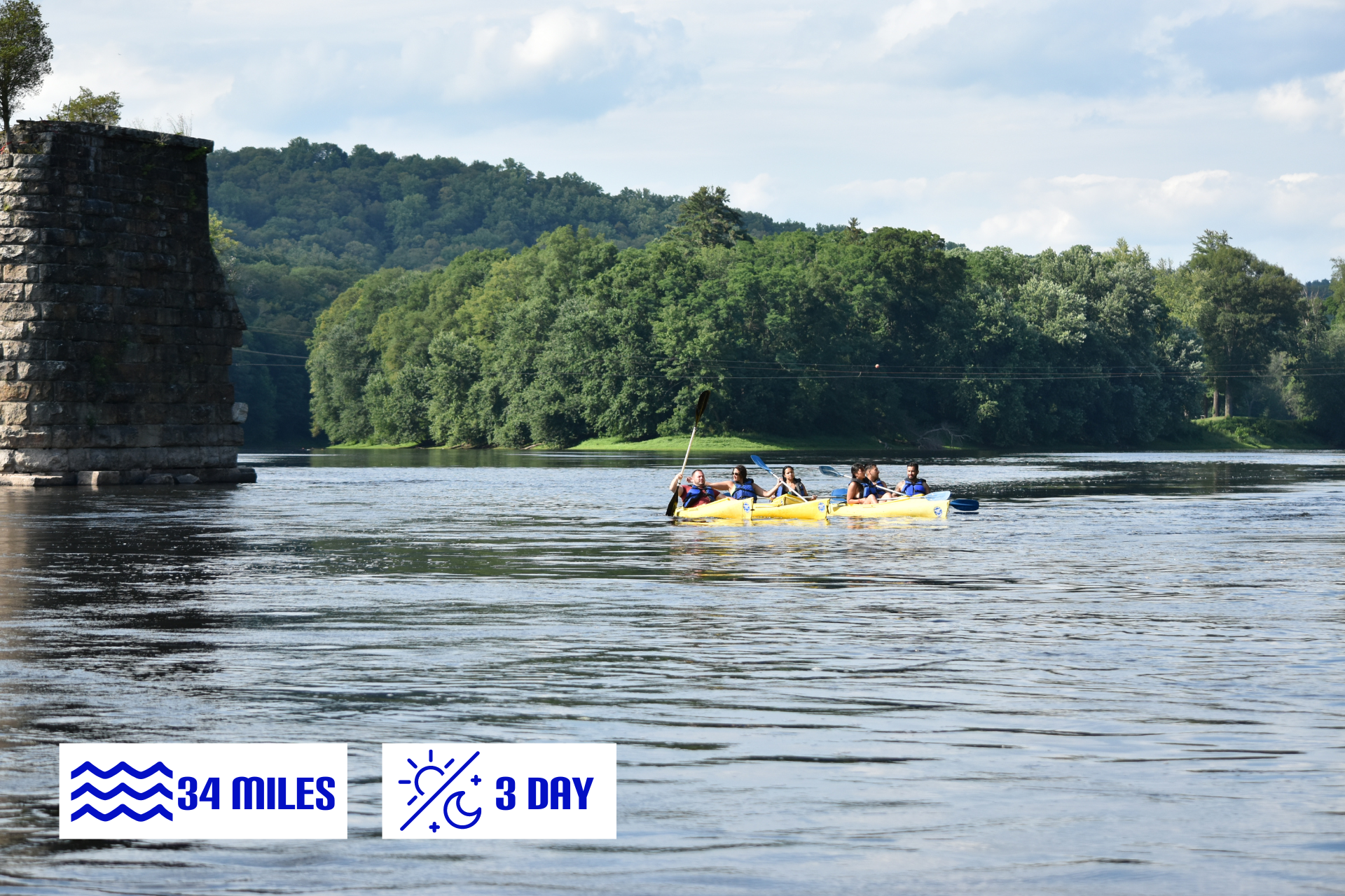 A group of people are rowing an Adventure Sports raft on a lake.