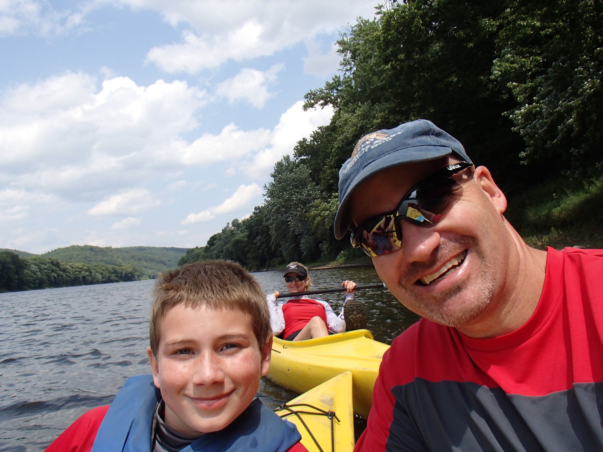A man and a boy in kayaks on a lake  at adventure sports
