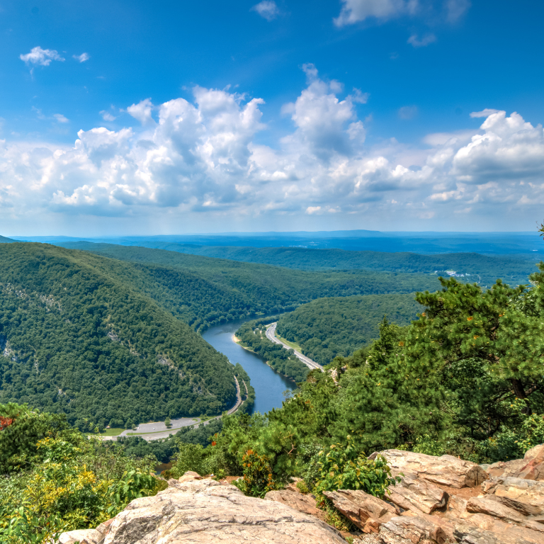 A river flowing through a valley surrounded by trees and rocks in the Poconos near adventure sports