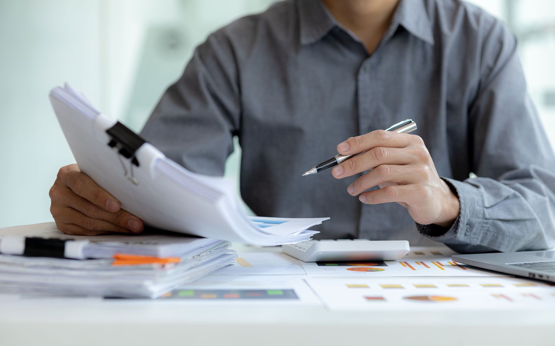 Lawyer reviewing papers at a desk with a brass balance scale and clipboard