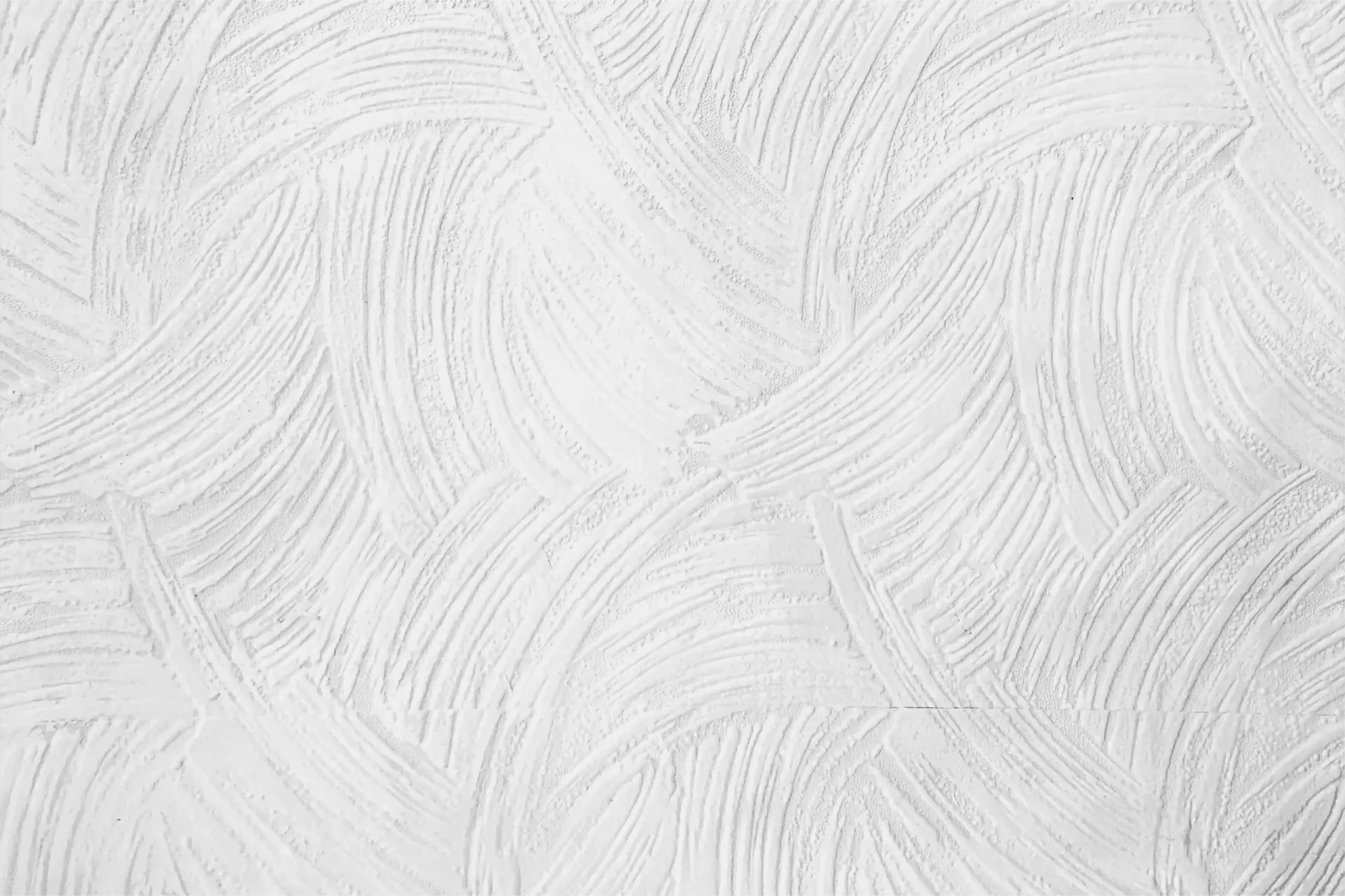 A close up of a white wall with a brush stroke pattern.