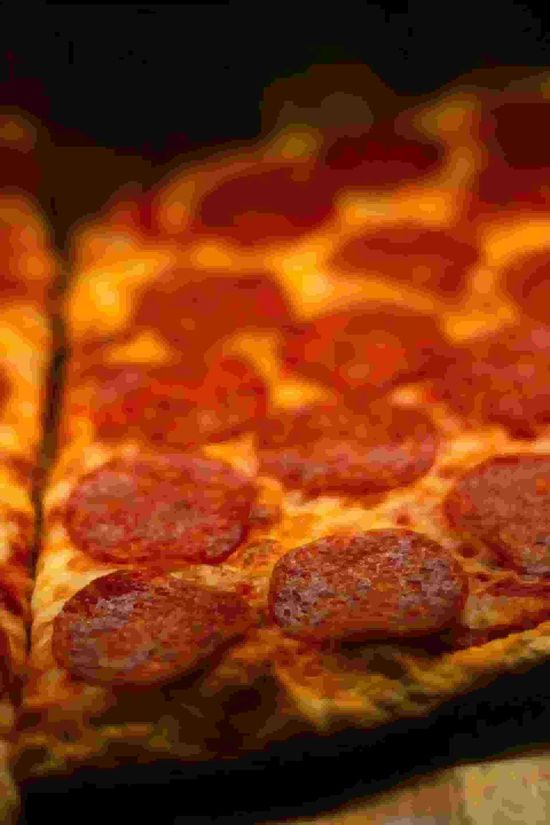 A close-up, angled view of a rectangular pepperoni pizza with melted cheese
