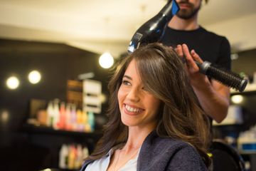 Woman smiling while getting a blowout at a salon