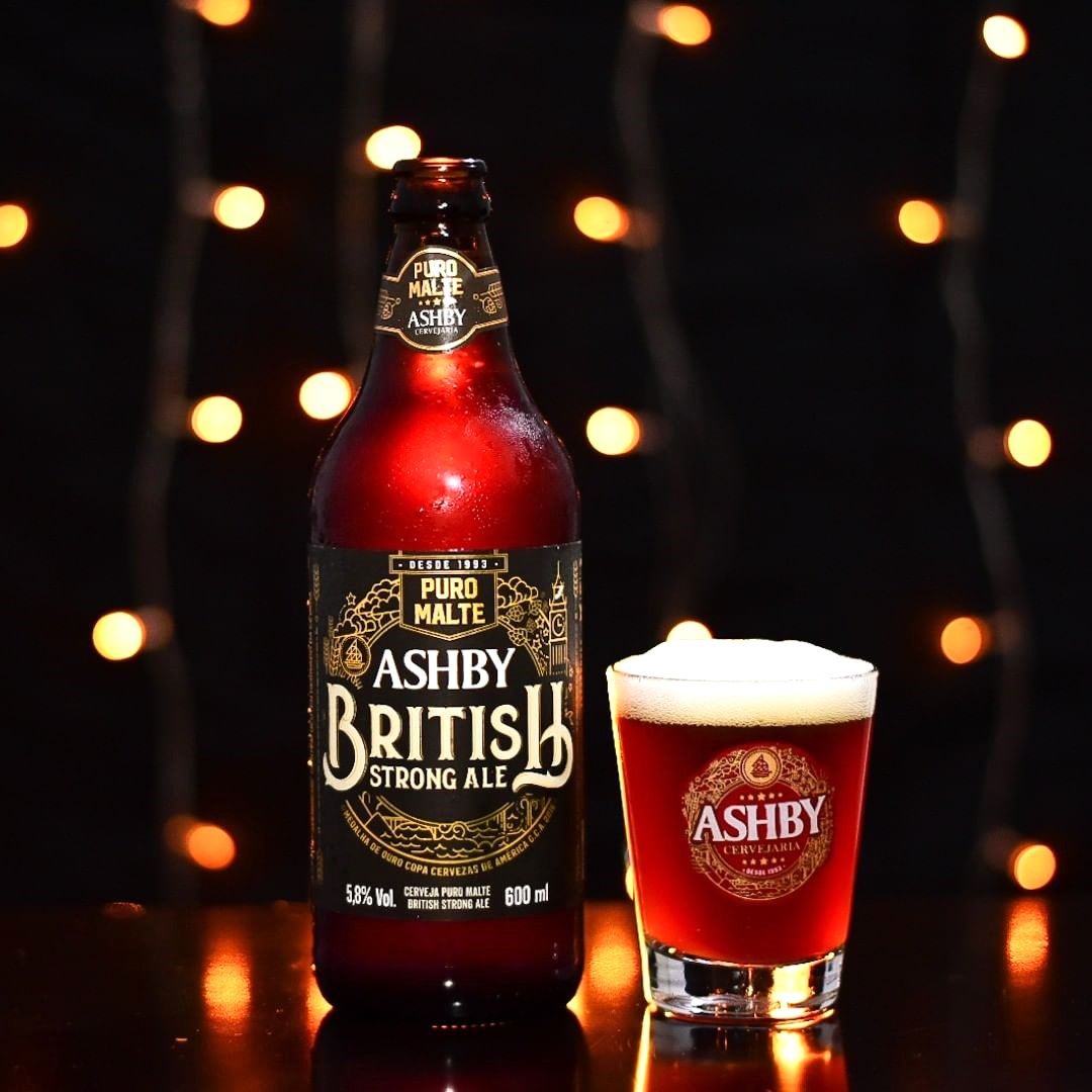 Uma garrafa de cerveja forte britânica Ashby ao lado de um copo de cerveja.