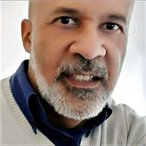 Um homem com barba está sorrindo para a câmera