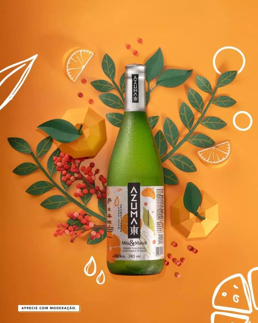 Uma garrafa de suco cercada por frutas e folhas em um fundo laranja.