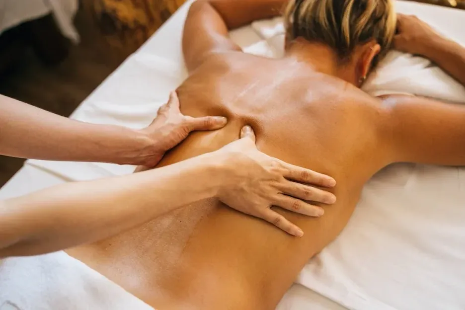 A woman is getting a massage on her back at a spa.