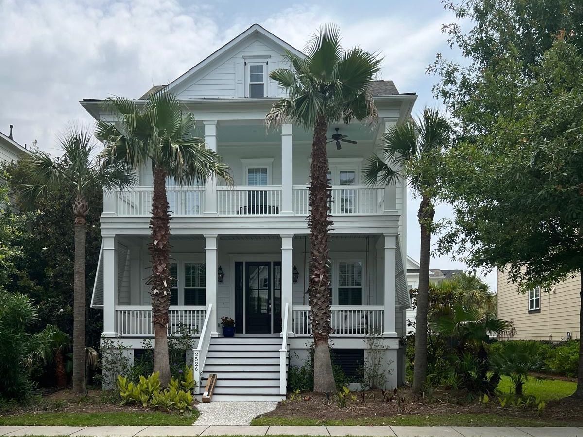 A large white house with palm trees in front of it