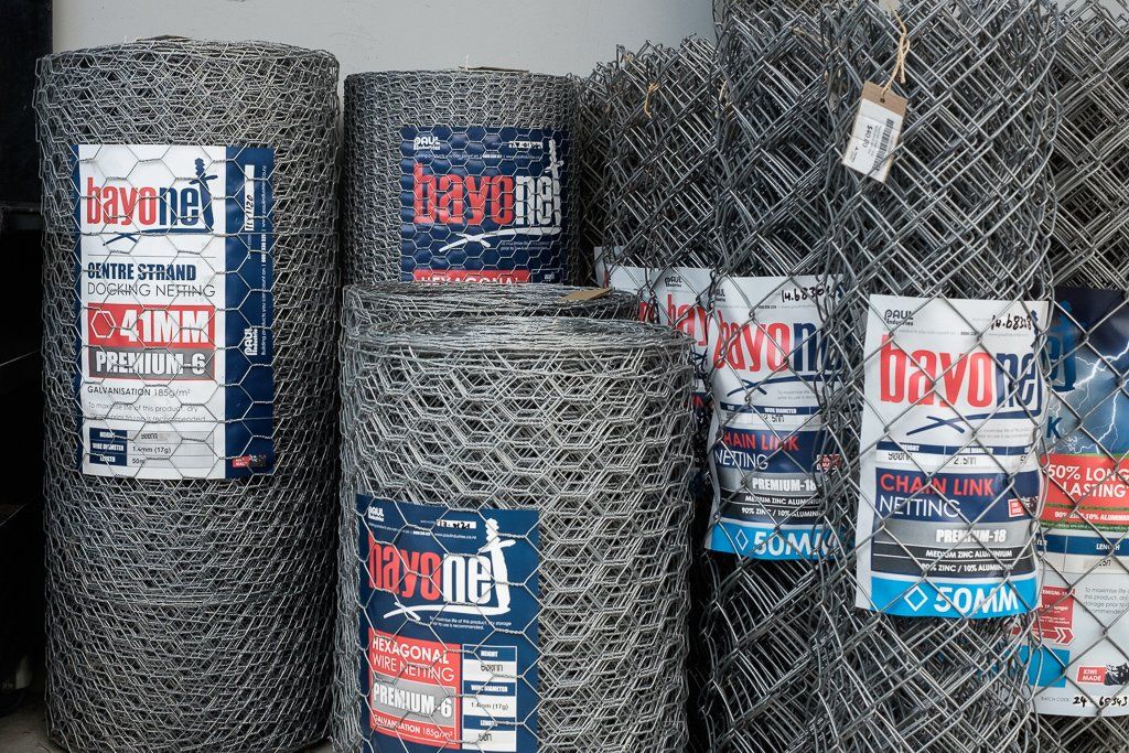 Several rolls of BavoNet galvanized hexagonal wire mesh fencing with product labels attached to them.