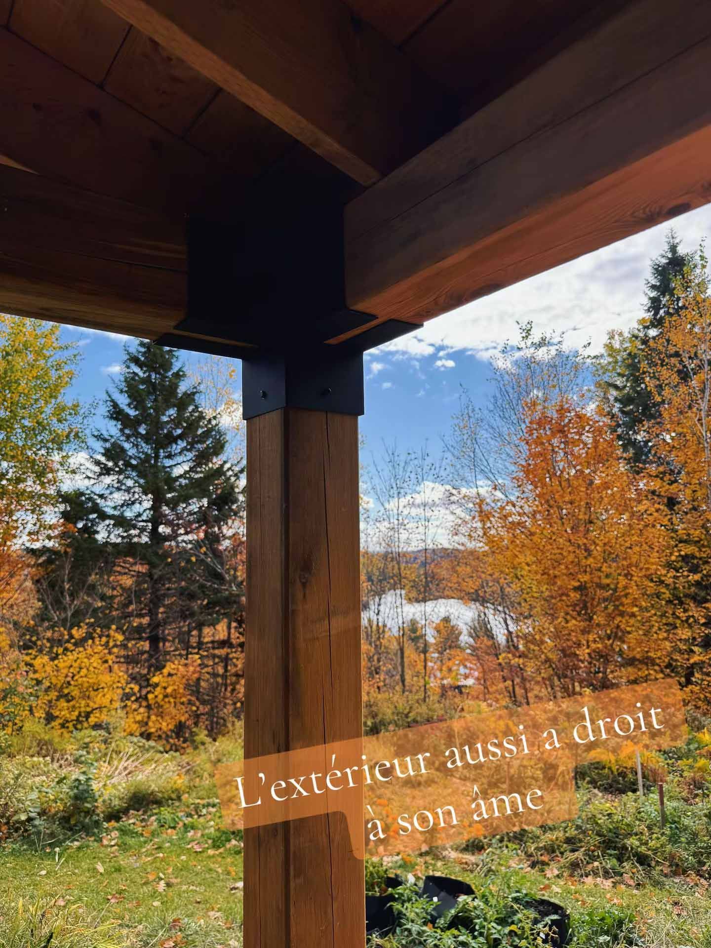 View of fall foliage and lake from under wooden porch, text reads