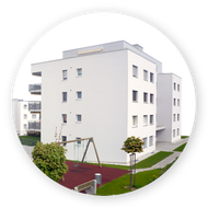 Un bâtiment blanc avec une aire de jeux devant lui