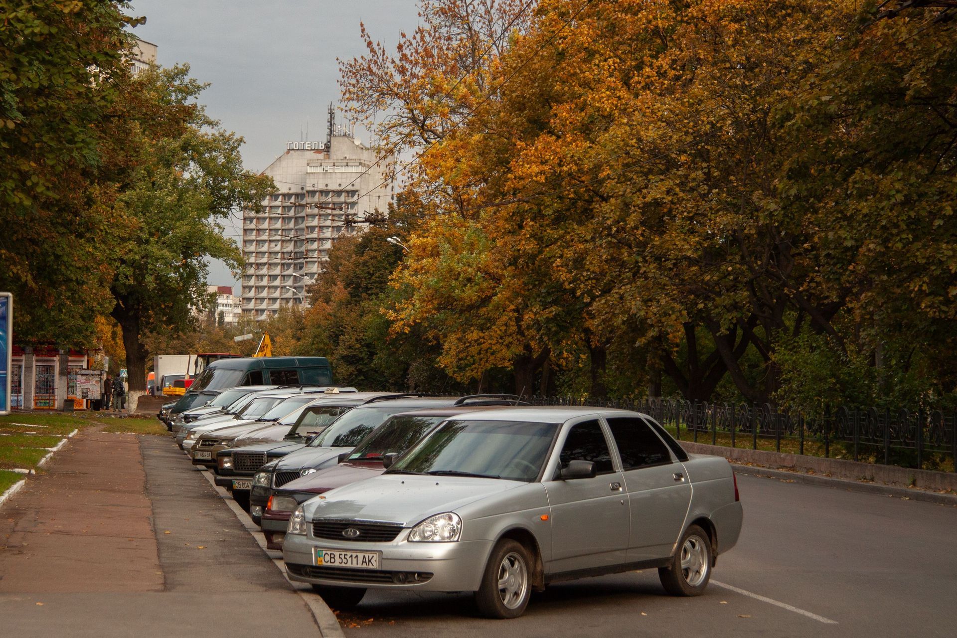 Silver car parked on a tree-lined street – parking nearby