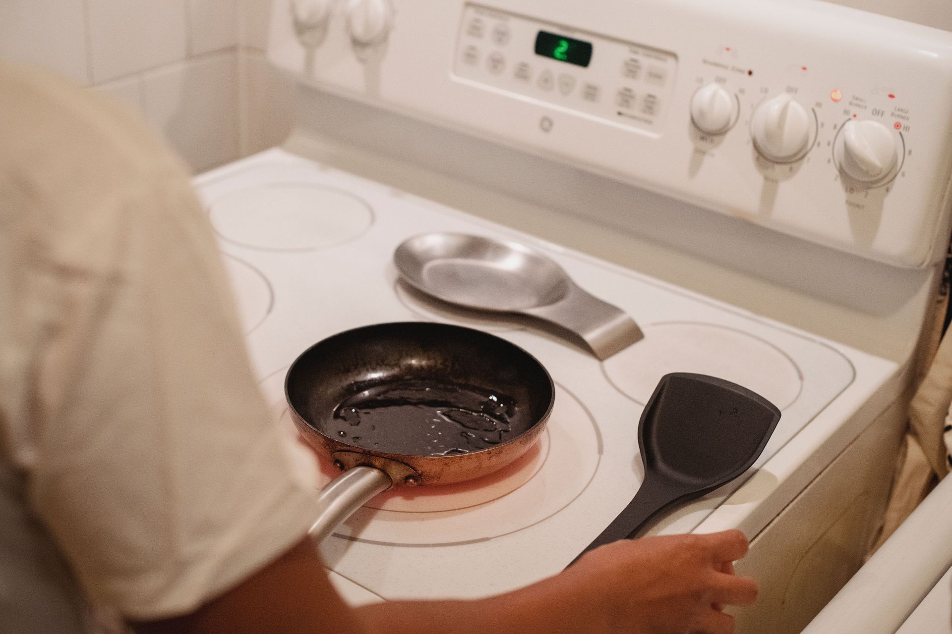Person cooking a pancake on an electric stove – fully equipped kitchen